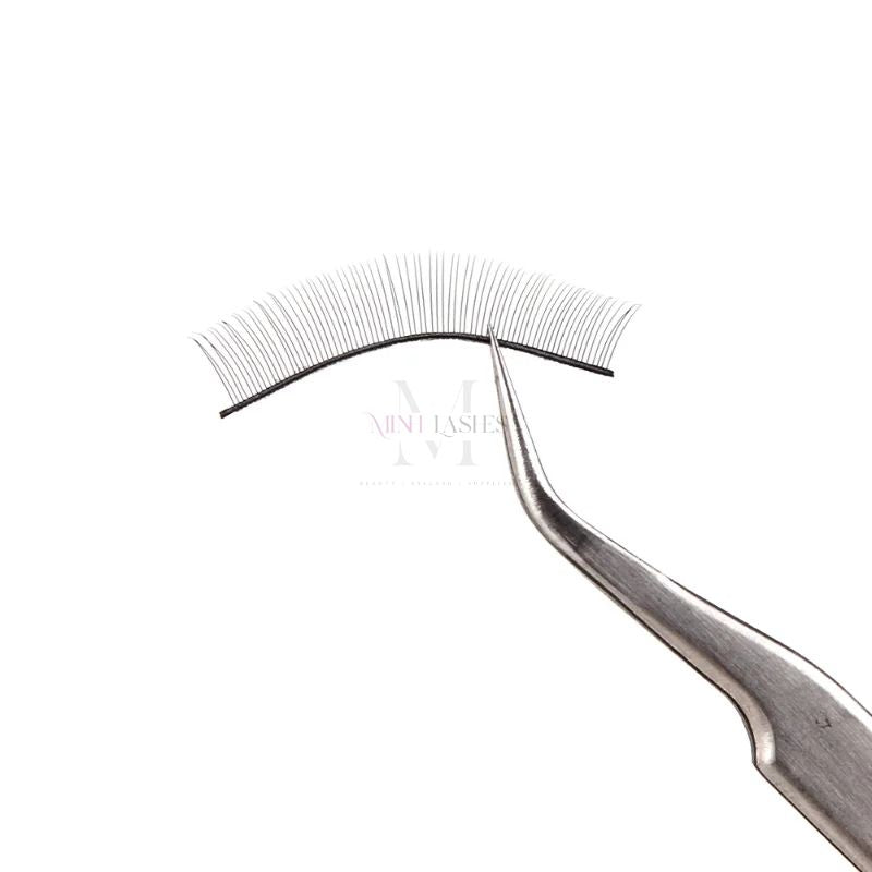 Training eyelashes being applied with tweezers for eyelash extension practice.