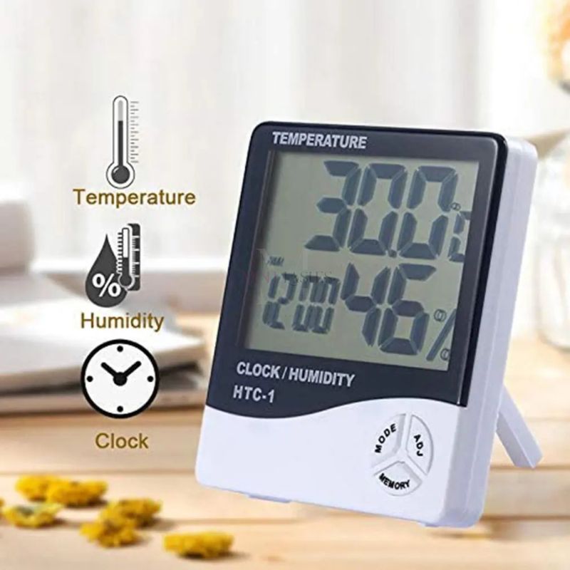 Angled view of a digital humidity and temperature clock used by eyelash technicians to monitor lash room conditions.